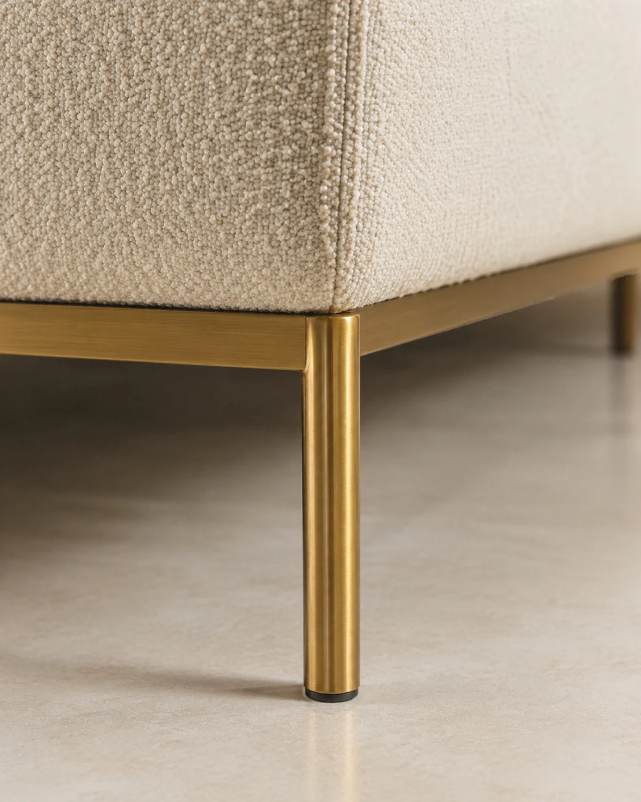 Brushed brass leg meeting the upholstered base